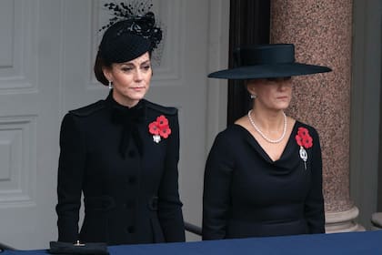 Kate compuso su estilismo con una chaqueta de inspiración militar, en cuya solapa llevó las amapolas rojas y el de la Guardia de Dragones de la Reina.
Lo complementó con unos pendientes de perlas que pertenecieron a Isabel II y un tocado de redecilla con flores tridimensionales. La duquesa de
Edimburgo, por su parte, eligió un vestido negro que combinó con sombrero de ala ancha, pendientes y gargantilla de perlas.