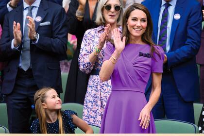 Kate lució un vestido de la firma inglesa Safiyaa realizado en uno de los colores del tradicional club. Lo acompañó con zapatos nude de charol y mini bag LK Benett. La princesa Charlotte llevó un vestido a lunares con volados en las mangas y lazo.