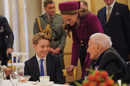 Kate, orgullosa de su hijo mayor, quien por primera vez participa de este acto, sonríe mientras lo escucha conversar con el veterano Alfred Littlefield.