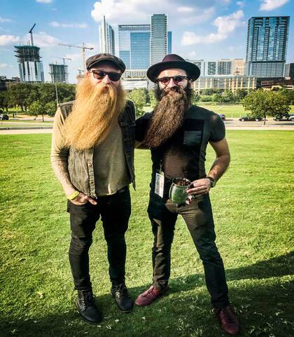 Keegan Ferrari, bajista de Four Stroke Baron, y su amigo posan con la barba levemente inclinada.