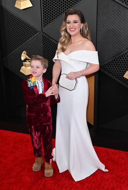 Kelly Clarkson, con vestido blanco con escote palabra de honor y clutch a tono, llegó acompañada por su hijo