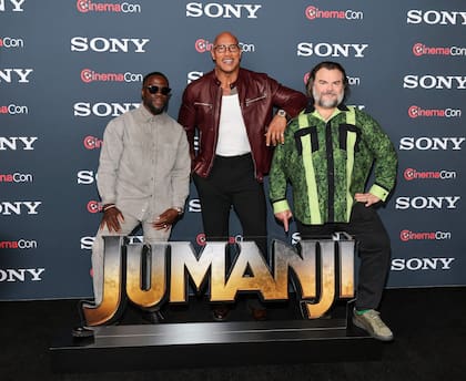 Kevin Hart, Dwayne Johnson y Jack Black frente al cartel promocional del regreso de Jumanji, presentado en Las Vegas este lunes