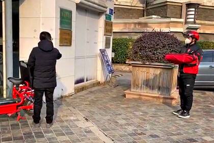 Mientras el cliente aguarda, el vendedor se saca la mochila, la coloca en el piso, toma el producto y lo coloca arriba.