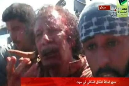 Khadafy, mal herido, es trasladado por los rebeldes a la fuerza