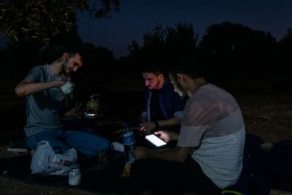 Khalid Najim, izquierda, Mustafa al-Jaafar y Ali al-Dalaati bebiendo mate en un parque en Idlib, Siria.
