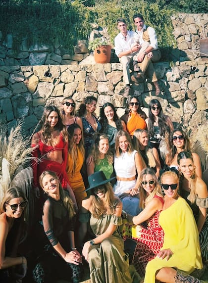 Kika posa con sus amigas invitadas. Desde lo alto, sentados sobre la pared de piedras, Gonzalo y su hijo Silvestre miran divertidos.