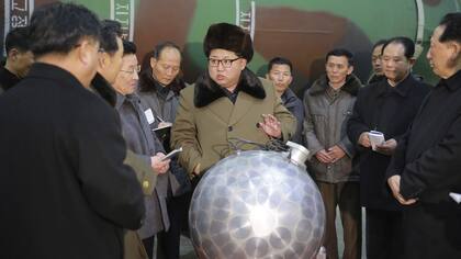 Kim Jong-un se muestra junto a una bomba nuclear en miniatura y amenaza a sus enemigos