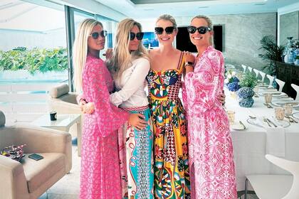 Kitty rodeada por sus hermanas, las mellizas Amelia y Eliza, y su espléndida madre, la exmodelo Victoria Lockwood, que lleva blusa blanca y falda celeste.