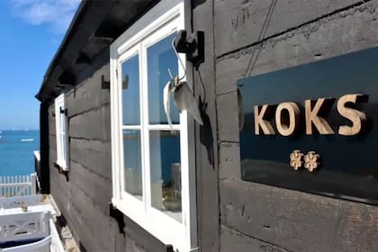 Koks ocupa un edificio histórico de madera negra en el paseo marítimo de Ilimanaq.