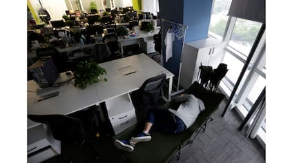 Kou Meng, director de producto de Renren Management Co., duerme en una cama plegable en la oficina por la mañana temprano