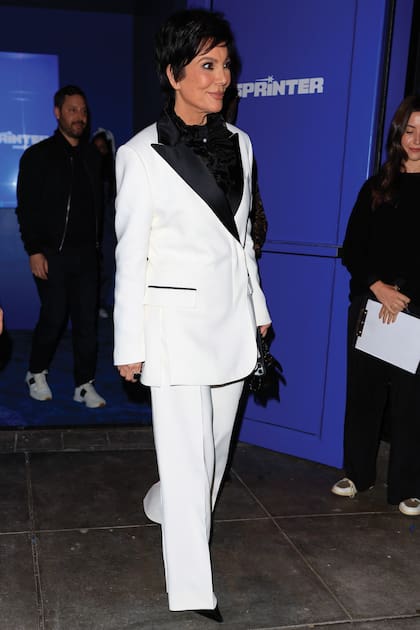 Kris Jenner, su madre, lució un elegante traje de chaqueta y pantalón sobre camisa con volados.
