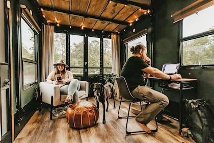 Kris y Andy trabajando y disfrutando del interior de su casa rodante, hasta con perro y plantas