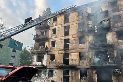 En esta foto difundida por la Administración Regional de Dnipro, trabajadores de emergencias extinguen un incendio tras el impacto de misiles en un edificio de apartamentos de varios pisos en Krivói Rog, Ucrania, el martes 13 de junio de 2023.