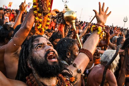 Hombres santos hindúes se sumergen en el agua del sagrado Sangam, la confluencia de los ríos Ganges, Yamuna y Saraswati