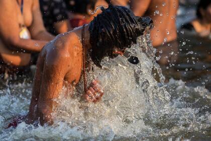 Un hombre santo hindú toma un baño en el día de Makar Sankranti durante el Kumbh Mela, en Prayagraj, estado de Uttar Pradesh, en la India