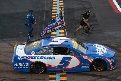 Kyle Larson porta la bandera con la leyenda de campeón; en 2020, mientras cumplía la sanción impuesta por NASCAR, participó en carreras de Midget y asistió en colegios de Minesotta a actos y charlas para conferencias sobre el racismo, la igualdad y la diversidad