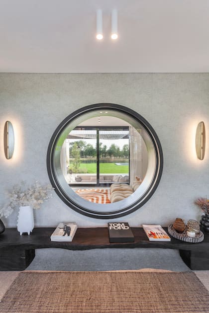 La abertura circular de este hogar en Pilará impacta en el hall y, como si fuera una lente gigante, permite atravesar con la vista el playroom, el conversation pit en la galería y llegar hasta la pileta.