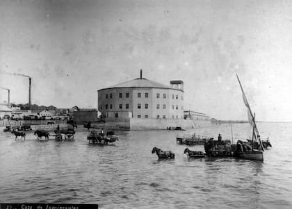 La actividad de los muelles no terminó con las carretas, que continuaron descargando mercaderías hasta la construcción del Puerto Madero. Al fondo, el primitivo Hotel de Inmigrantes.