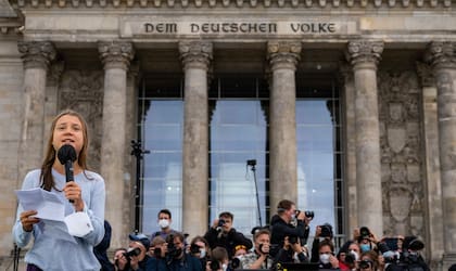 La activista climática sueca Greta Thunberg, frente al edificio del Reichstag, se dirige a los manifestantes que participan en una huelga climática global de Fridays for Future en Berlín el 24 de septiembre de 2021