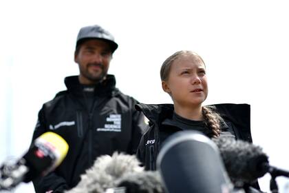 La activista climática sueca Greta Thunberg, acompañada por el capitán alemán del velero Malizia II, Boris Herrmann, habla durante una conferencia de prensa en el Mayflower Marina en Plymouth, suroeste de Inglaterra hoy, antes de su viaje
