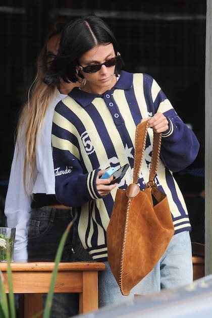 La actriz completó su look con una cartera de gamuza.