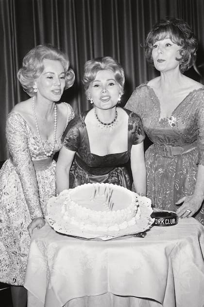 La actriz flanqueada por sus hermanas –Eva (izquierda) y Maga (derecha)–, celebrando su cumpleaños en el Stork Club. Las velas forman un signo de interrogación, porque ella ocultó su edad toda la vida.