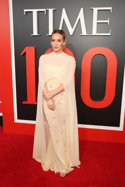 La actriz Hilary Duff se subió a la tendencia de las transparencias -y las largas capas- y lució un vestido de Anna October en color amarillo manteca con detalles bordados que resaltaron su impronta romántica
