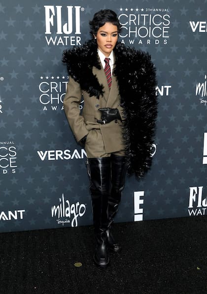 La actriz Teyana Taylor, nominada a mejor actriz de reparto por Una batalla tras otra, cruzó la alfombra roja con un look disruptivo que dio de qué hablar: un conjunto de Saint Laurent que combinó un traje en color café, camisa blanca, corbata, unas eternas botas negras y una estola de plumas