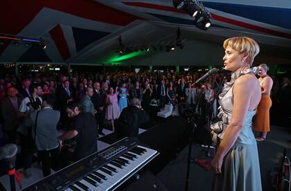 La actriz y cantante argentina de ascendencia británica Lucila Gandolfo,graduada de la Royal Academy of Music, interpretó los himnos nacionales de la Argentina y del Reino Unido