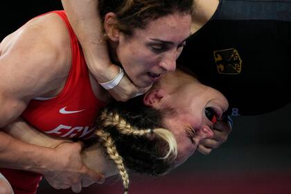 La alemana Anna Carmen Schell, a la derecha, reacciona durante su pelea contra la egipcia Enas Ahmed en el combate de lucha libre femenino de 68 kg