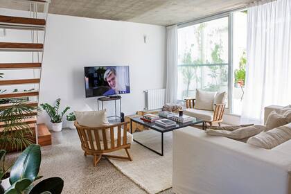 Sillón de dos cuerpos (Mema Lerena), sillones ‘Gervasoni’ (Maifren Muebles) con asiento tapizado en tussor off white y almohadones con funda de lino. Tacos ‘Álamo’ (Net Muebles). Alfombra (Elementos Argentinos). Mesa con tapa de mármol negro (VK Home).