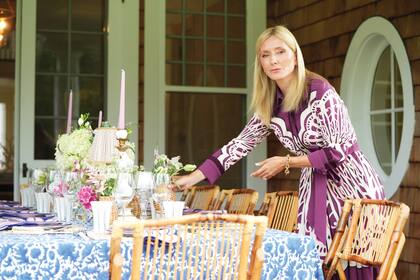 La anfitriona termina de poner una de las
mesas.