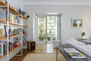 La apertura de un vano en el pasillo permitió conectar el living con el patio y ganar luz natural. La dueña recicló el mármol de un antiguo mueble de cocina y armó una consola con un pupitre escolar.