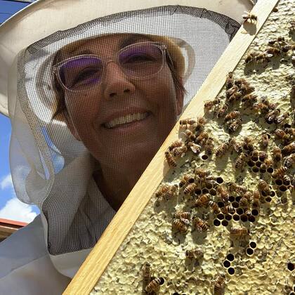 La apicultora se pone entonces unos guantes protectores y empieza a sacar los paneles de panal cubiertos de abejas
