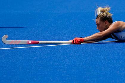 La argentina Sofia Maccari pierde el equilibrio mientras persigue el balón durante un partido de hockey sobre césped femenino contra Australia.