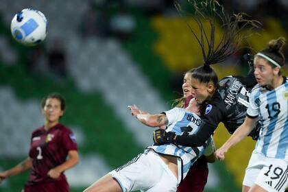 La arquera venezolana Nayluisa Cáceres sale enérgicamente para despejar la pelota entre Florencia Bonsegundo y Mariana Larroquette.