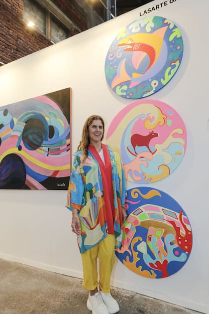 La artista Valeria Costantini junto a su obra, con un carpincho
