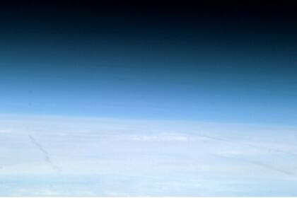 La atmósfera terrestre azul y el espacio frío y negro en el fondo