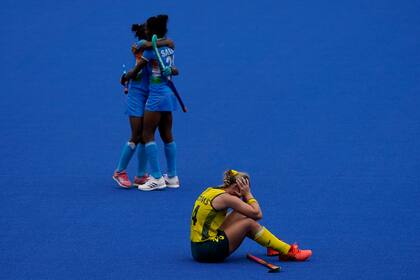 La australiana Mariah Williams, abajo, se sienta en la cancha después de perder su partido de hockey sobre césped femenino contra India