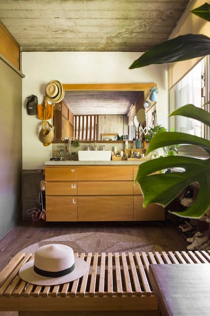 La bacha enfrente de la cama fue una idea de Jorge. “Hay un solo baño y esto ayuda un montón”. Velador y espejos (Hydra Home).