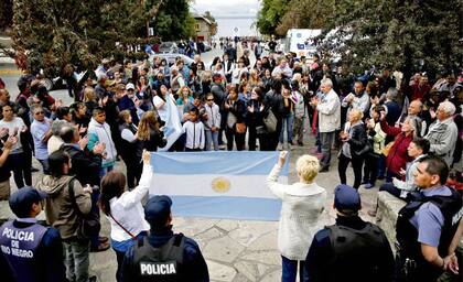 La bandera argentina encabezó la movilización de los vecinos; atrás una marcha opositora