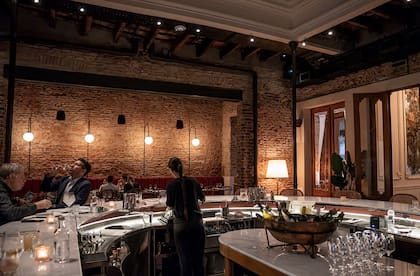 La barra de mármol y madera dialoga muy bien con los materiales históricos de la casona