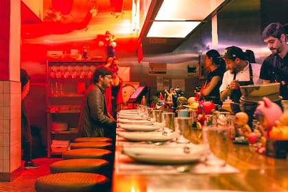 La barra tiene apenas once lugares, un número impar ideal para conversar con los cocineros, los vecinos y observar el frenético servicio