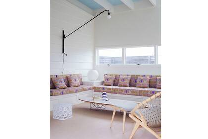 La base neutra (en blanco) permite jugar con los detalles sin saturar. Aquí, los almohadones estampados equilibran el espacio. Foto: blog.brooksandfalotico.com