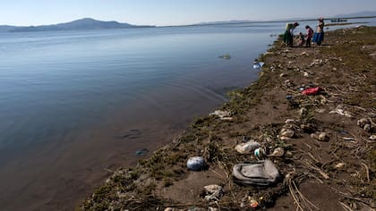 La basura cubre la costa del lago Titicaca, donde la activista ambiental Maruja Inquilla habla con los habitantes de Coata, en la región de Puno, Perú