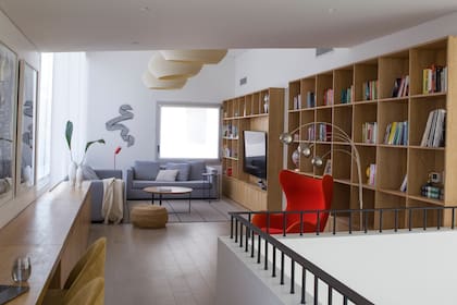 La biblioteca de 2,20m de alto y el escritorio fueron diseñados por RDR Arquitectos en madera de kiri. Pisos laminados alemanes 'Roble Trend Grey' de Kronotex.