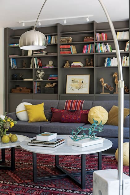 La biblioteca de la casa y el sofá engamado, con almohadones cuadrados, alargados y
bombón (Salazar Casa). Esculturas en bronce, de Elisa Bunge, y cuadro de Rodrigo García Berro.