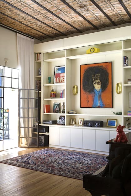 La biblioteca se diseñó con guías especiales para bajar un paño a control remoto y, en un instante, convertir la sala en un cine.