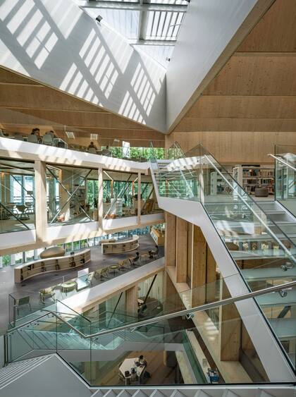 La biblioteca se organiza en torno a un amplio patio triangular que conecta los usos a la escalera principal. El vacío de la escalera lleva luz natural a los ambientes y actúa como “chimenea solar” mejorando la ventilación natural.