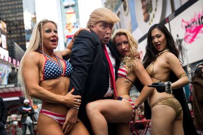 La británica Alison Jackson, disfrazada de Trump, se burla del republicano junto a una chicas en bikini